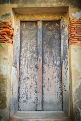 View of old ancient weathered double doors in Thai temple.