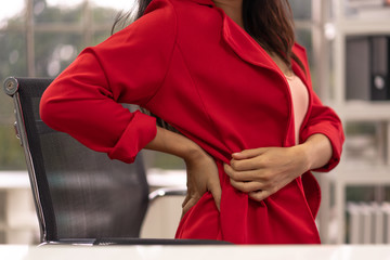 Business woman have back pain caused by working in the office. Office Syndrome.
