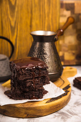 Dessert with cocoa brownies in chocolate near tea pot and coffee turk