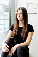 Brunette are sitting near window in gym
