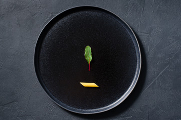The concept of pasta Penne with chard, minimalism. Dark background, top view, space for text