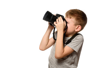 Boy takes pictures on the camera. Portrait. Isolate on white background. Side view