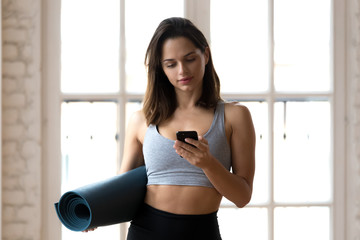 Fit female athlete use smartphone waiting for training