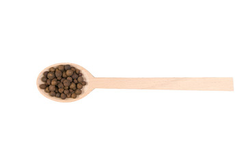 allspice on wooden spoon isolated on white background