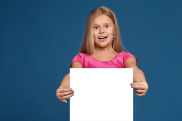 Portrait of adorable emotional little girl on blue background