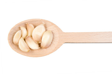 garlic cloves on wooden spoon isolated on white background