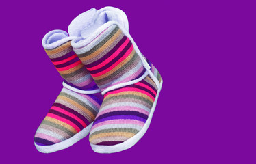 Woolen uggs with colored stripes on a purple background.