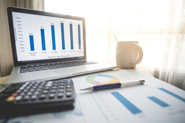 Business financial concept , Laptop ,pen, coffee,smartphone, graph for finance and business on the table