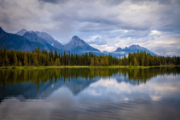 Fototapeta na wymiar Mountains reflecting in the calm waters of Spillway Lake in Peter Lougheed Provincial Park, Alberta, Canada
