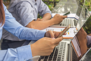 Side view of businesswoman and businessman working on smartphone