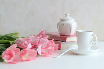 Still life composition with pink tulips, coffee cup and sugar pot