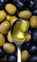 Black and green olives mix with spoon