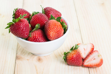 Strawberries are ripe in a cup that is placed on the wood