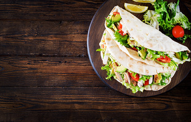 Pita bread sandwiches with grilled chicken meat, avocado, tomato, cucumber and lettuce served on ...