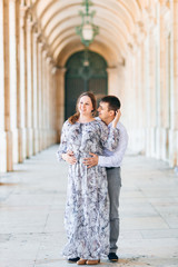 Fototapeta premium The guy hugs the girl from the back side and looks at her in the
