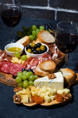 cheese platter, bread, fruit and cold cuts to wine, vertical closeup