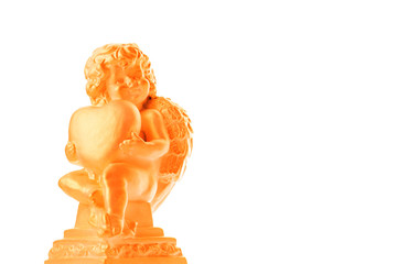Golden Cherub statue with red heart on an isolated white background. Angel holding a heart of love