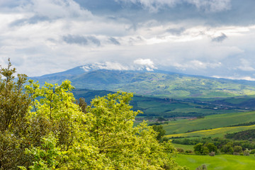 Obraz premium Beautiful landscape view in Tuscany with storm clouds and a mountain