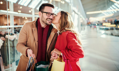 Shopping time. Young couple shopping together in shopping mall. Consumerism, love, dating, lifestyle concept