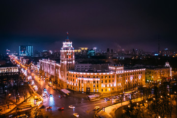Fototapeta na wymiar Arial view of famous Voronezh building with tower in night, symbol of Voronezh and evening cityscape with rads, parks and traffic, drone shot