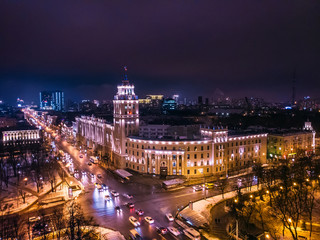 Fototapeta na wymiar Arial view of famous Voronezh building with tower in night, symbol of Voronezh and evening cityscape with rads, parks and traffic, drone shot