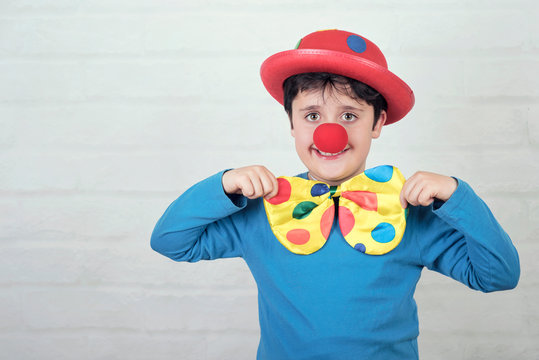 child with clown nose and hat