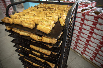Bakery stand with racks of freshly baked cookies in cookie factory