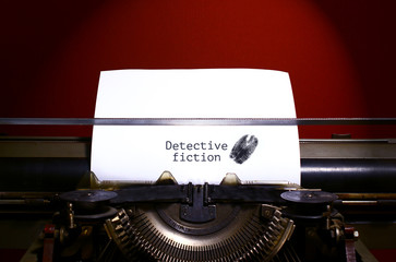 Typewriter spelling detective fiction on paper with finger print