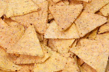 background of salted yellow tortilla chips maed with corn