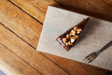 Obraz na płótnie Canvas Slice of nutty chocolate cake sitting on a cafe table