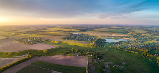 Aerial view of the fresh bright green lush countryside at sunset