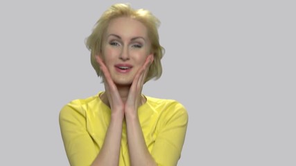 Beautiful excited woman fooling around. Slow motion funny middle-aged woman having fun on gray background. Human facial expressions. - Powered by Adobe