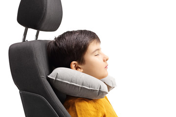 Boy sleeping in a car seat with a travel pillow around his neck