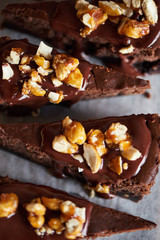 Slices of chocolate cake with nuts sitting on a table