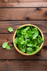 Fresh spinach leaves on wooden background. Healthy vegan food. Top view.