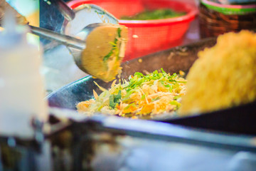 Close up hand of vendor during cooking for Padthai, the original Thai Fried Noodle, stir-fried noodle with shrimp and egg commonly served as a street food popular in Thailand