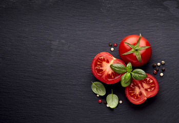 fresh  tomatoes and basil on black  stone background