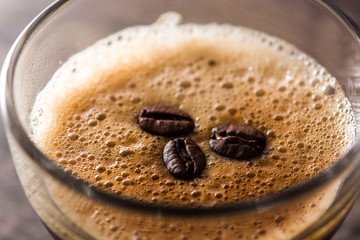 coffee glass and coffee grain on wooden table. Close up