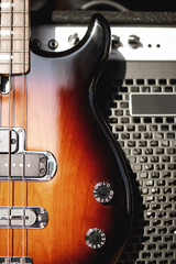 Playing guitar...Close up photo of a brown electric guitar with volume and tone control knobs and amplifier