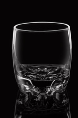 Empty glass on black background with highlights.
