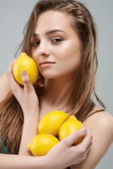 Beautiful young woman with wet make up holding lemon. Healthy Lifestyle. Youth and Skin Care Concept
