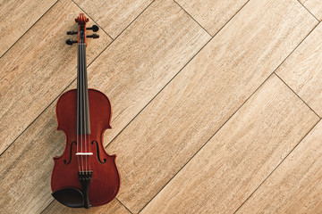 Fototapeta na wymiar Classic musical instrument. Top view of the brown violin on the wooden floor