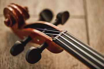 Construction of violin. Top view of the violin neck lying on wooden background © Friends Stock