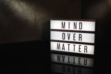 Mind over matter motivational message on a light box in a cinematic moody background
