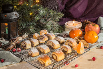 Fresh homemade buns with cinnamon and fruits on wooden table