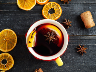Mug of warm mulled wine from red wine with spices and citrus