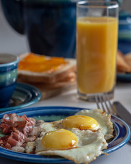 Breakfast with bacon, fried eggs, and toasts