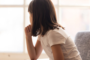 Sad thoughtful little girl feeling hurt depressed bored looking away