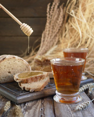 slices of bread with honey and tea in glasses in rustic decoration