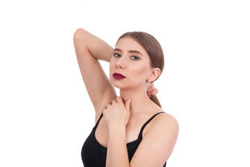 Fototapeta premium Portrait of a young beautiful girl with make-up isolated on white background. A woman holds her long hair with her hand.